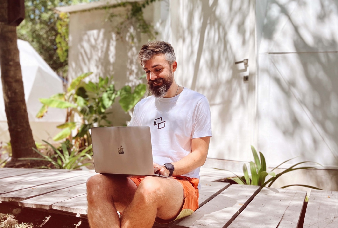A participant smiling at his laptop outdoors